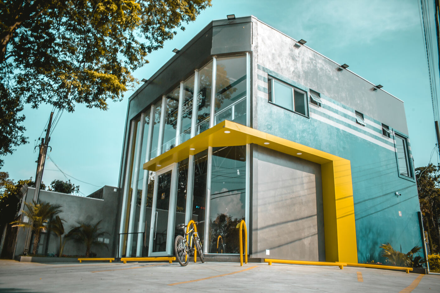 Fachada da HD Training em Interlagos, com a estrutura de vidro e o toldo amarelo