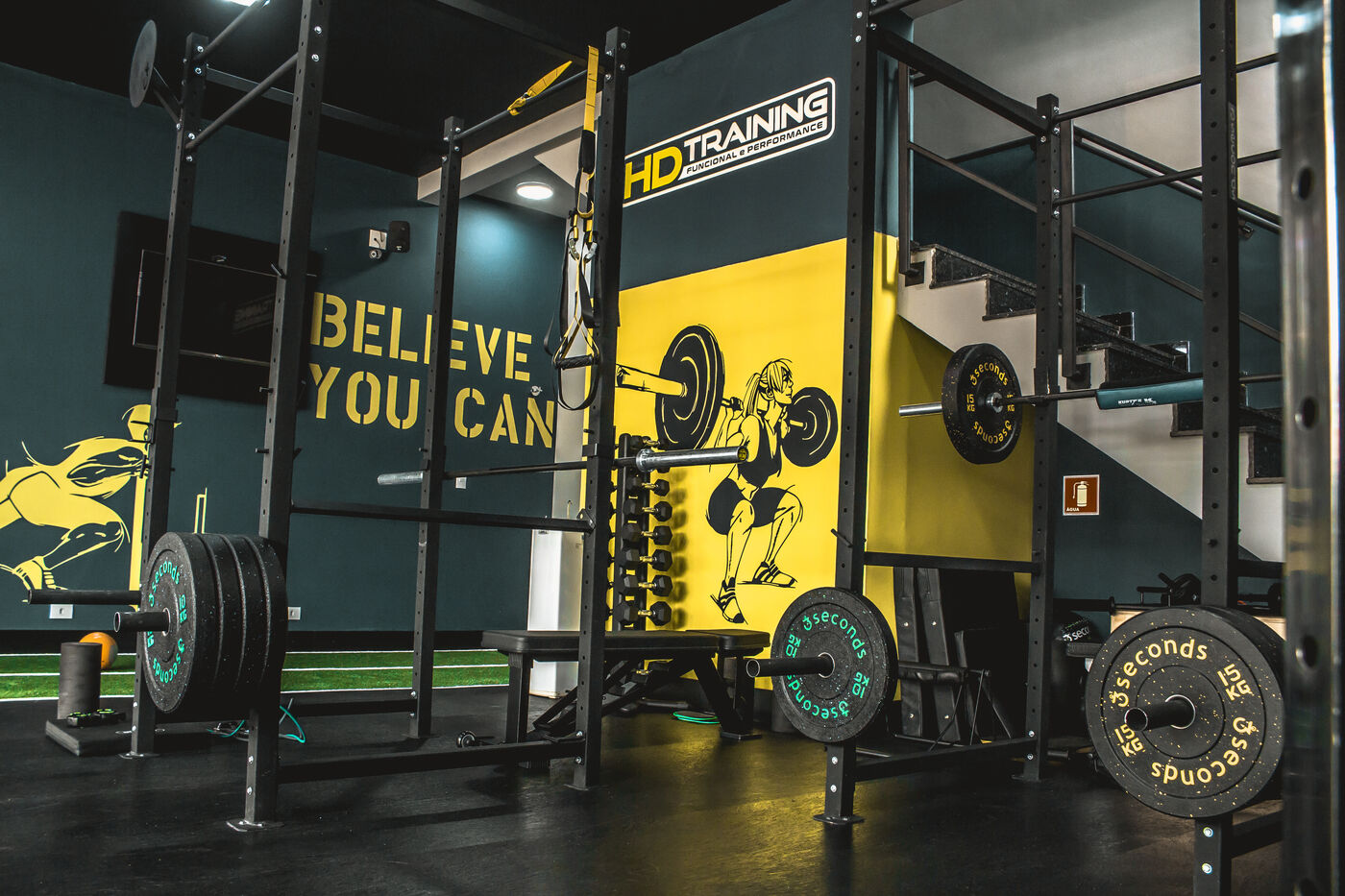 Rack, anilhas e acessórios da HD Training junto à parede da marca